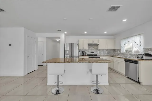 a kitchen with stainless steel appliances granite countertop a sink and cabinets