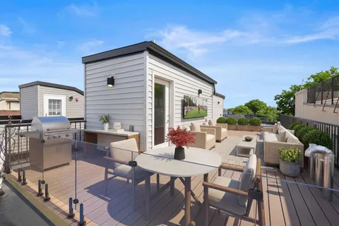 a view of a patio with couches and table and chairs with wooden floor and fence