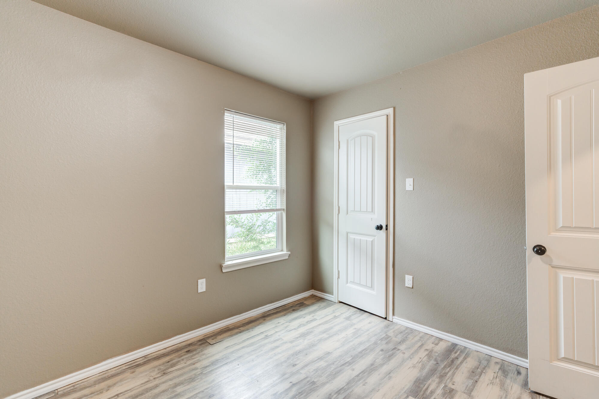 2832 East 7th Street Lubbock, TX 79403 - Photo 19 of 25 a view of an empty room with wooden floor and a window