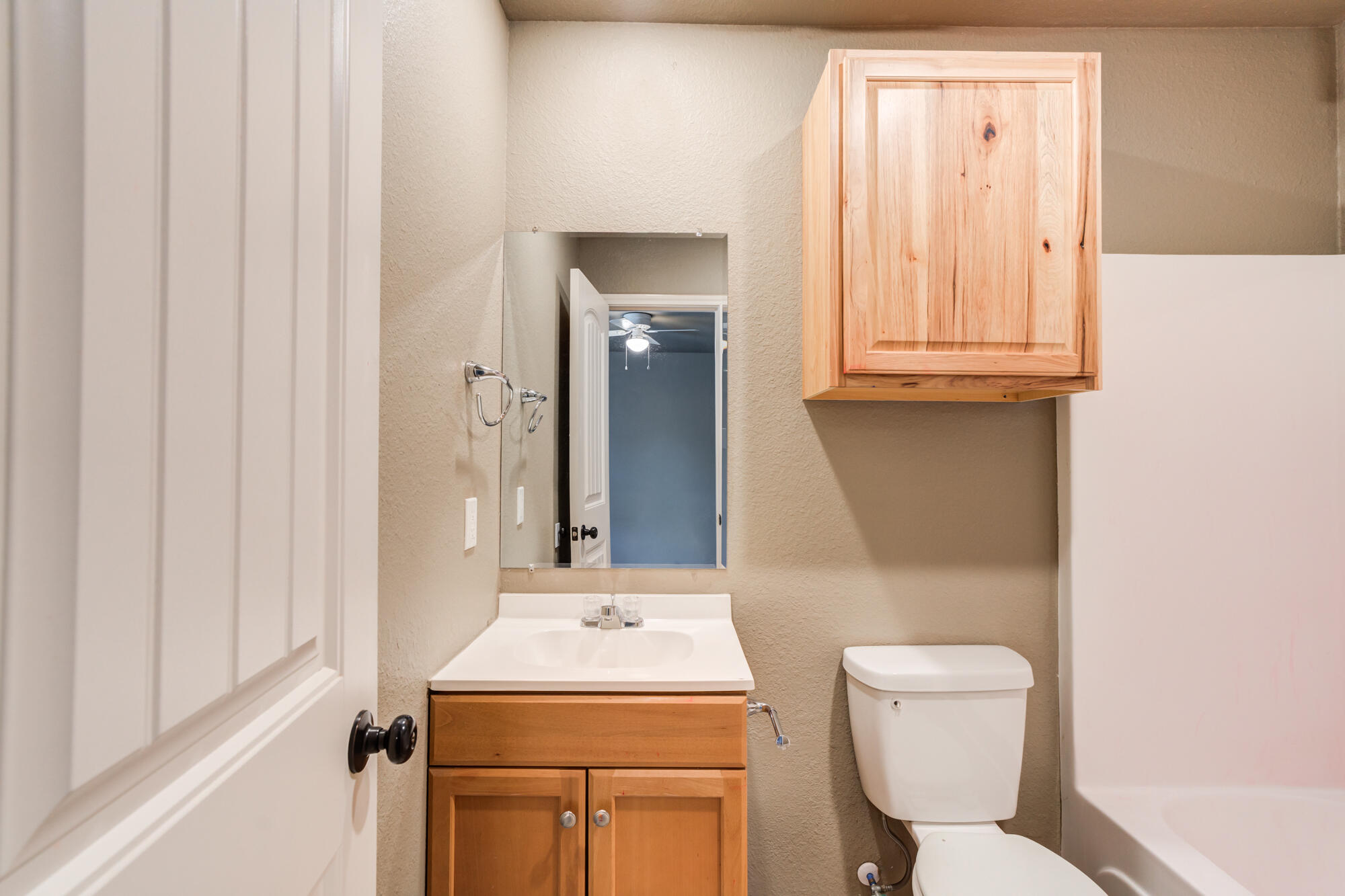 2832 East 7th Street Lubbock, TX 79403 - Photo 25 of 25 a bathroom with a toilet sink vanity and mirror