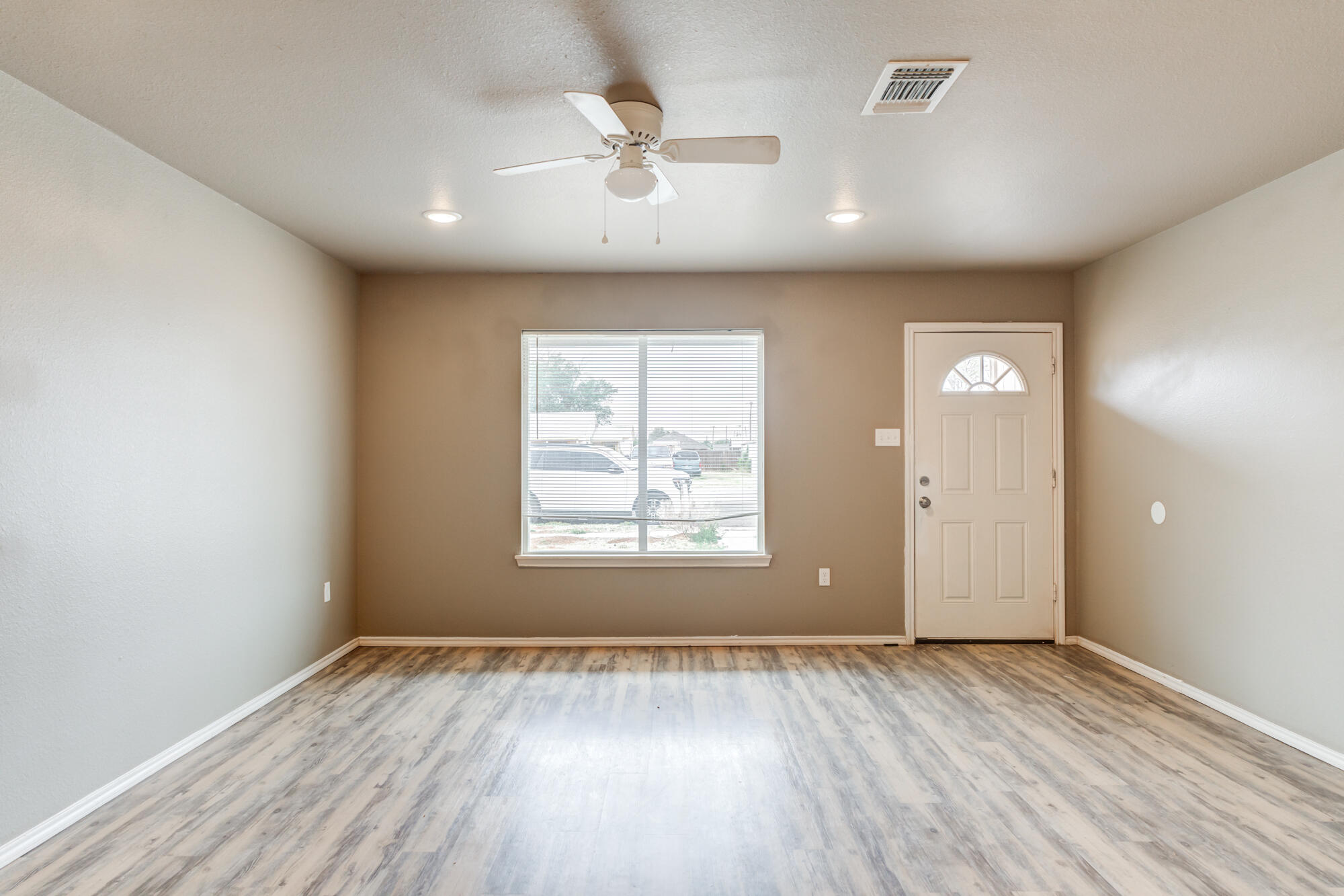 2832 East 7th Street Lubbock, TX 79403 - Photo 4 of 25 an empty room with wooden floor and windows