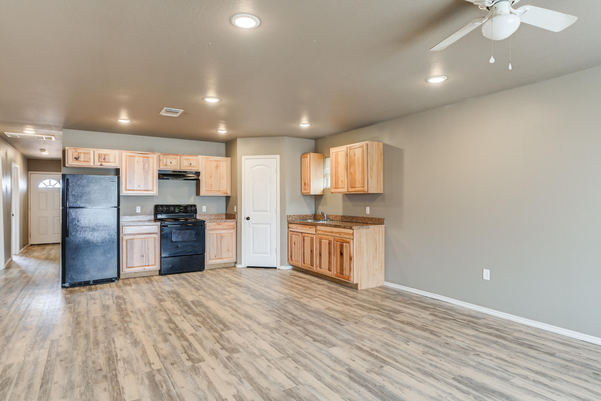 2832 East 7th Street Lubbock, TX 79403 - Photo 8 of 25 a kitchen with stainless steel appliances kitchen island granite countertop a refrigerator and a wooden floors