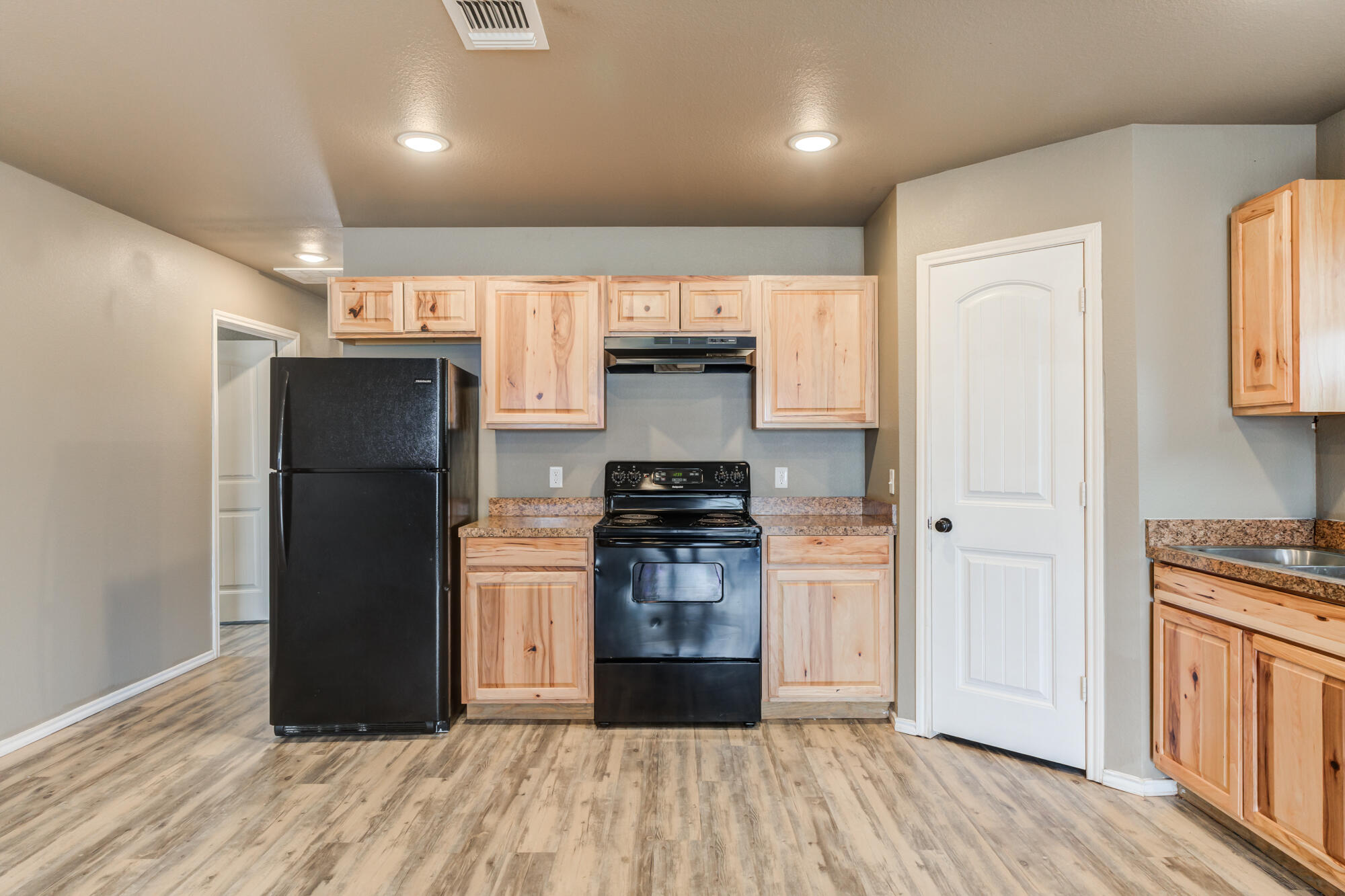 2832 East 7th Street Lubbock, TX 79403 - Photo 10 of 25 a kitchen with a refrigerator and a stove top oven