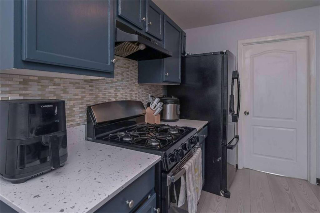 113 Millwheel Drive Villa Rica, GA 30180 - Photo 12 of 34 a kitchen with stainless steel appliances granite countertop a stove a refrigerator and a sink with wooden floor