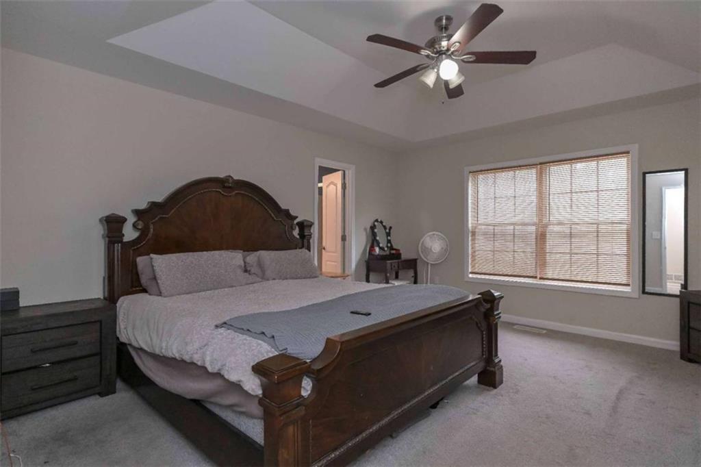 113 Millwheel Drive Villa Rica, GA 30180 - Photo 15 of 34 a bedroom with a bed and a chandelier