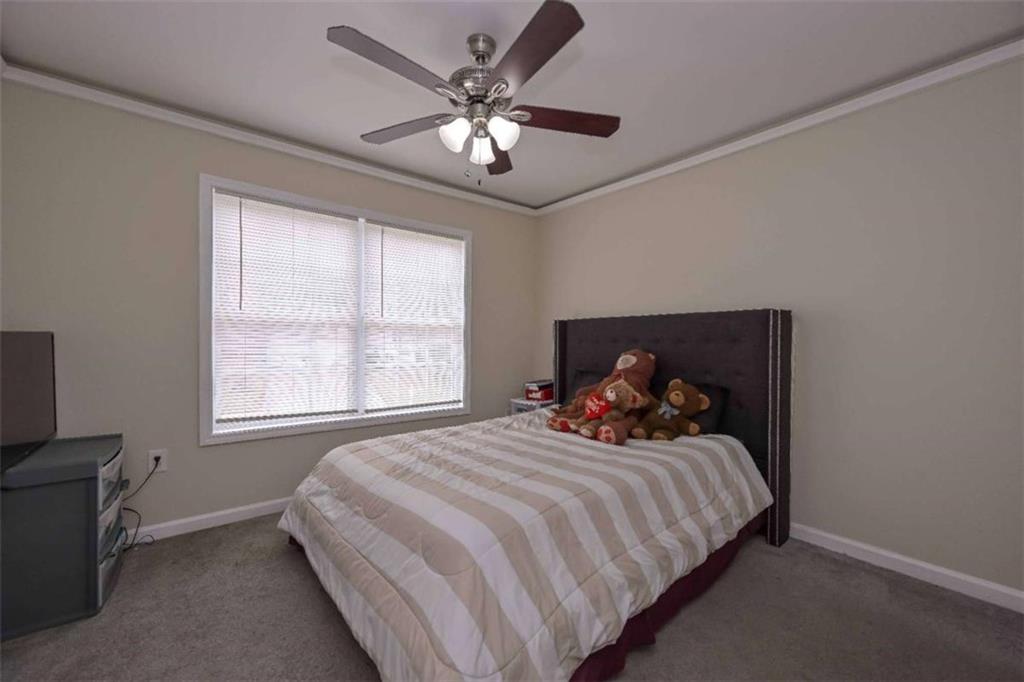 113 Millwheel Drive Villa Rica, GA 30180 - Photo 19 of 34 a bedroom with a bed and a chandelier