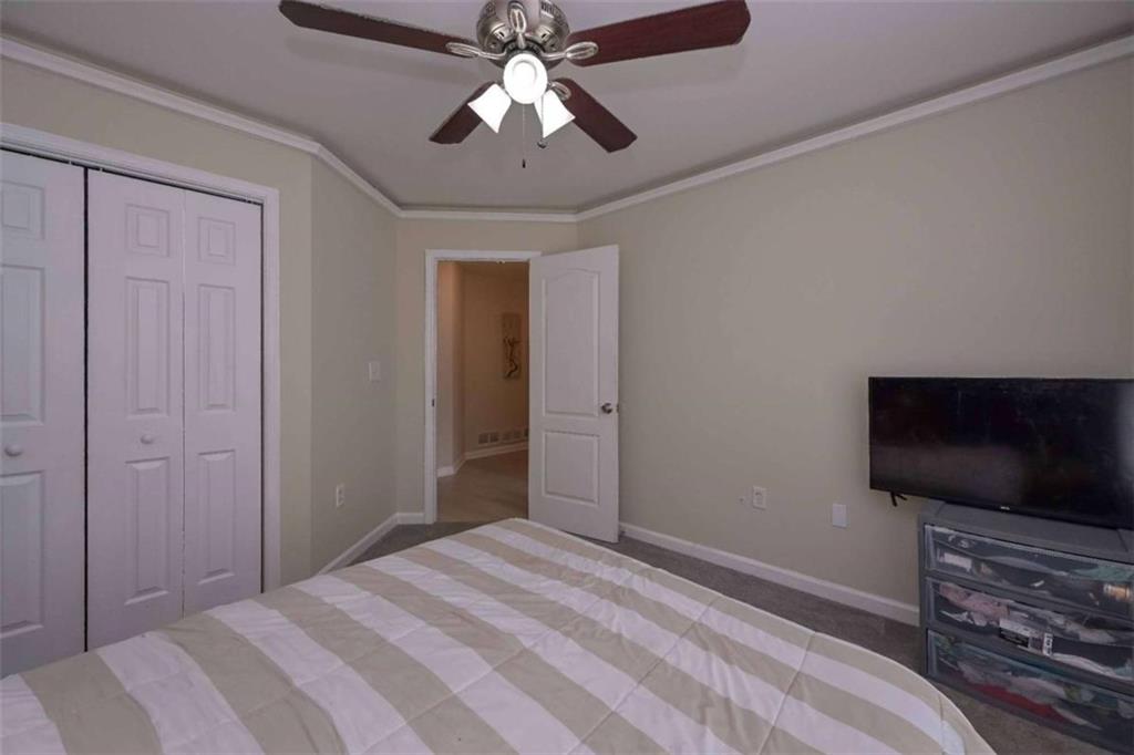 113 Millwheel Drive Villa Rica, GA 30180 - Photo 20 of 34 a bedroom with a bed and a flat screen tv