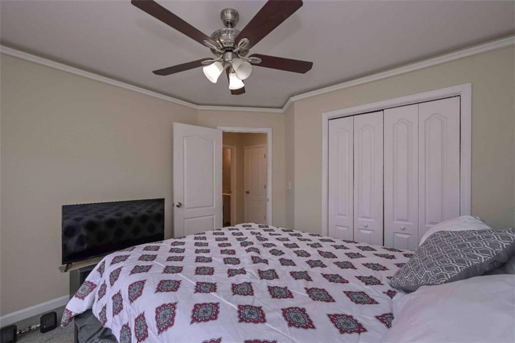 113 Millwheel Drive Villa Rica, GA 30180 - Photo 22 of 34 a bedroom with a large bed and a chandelier
