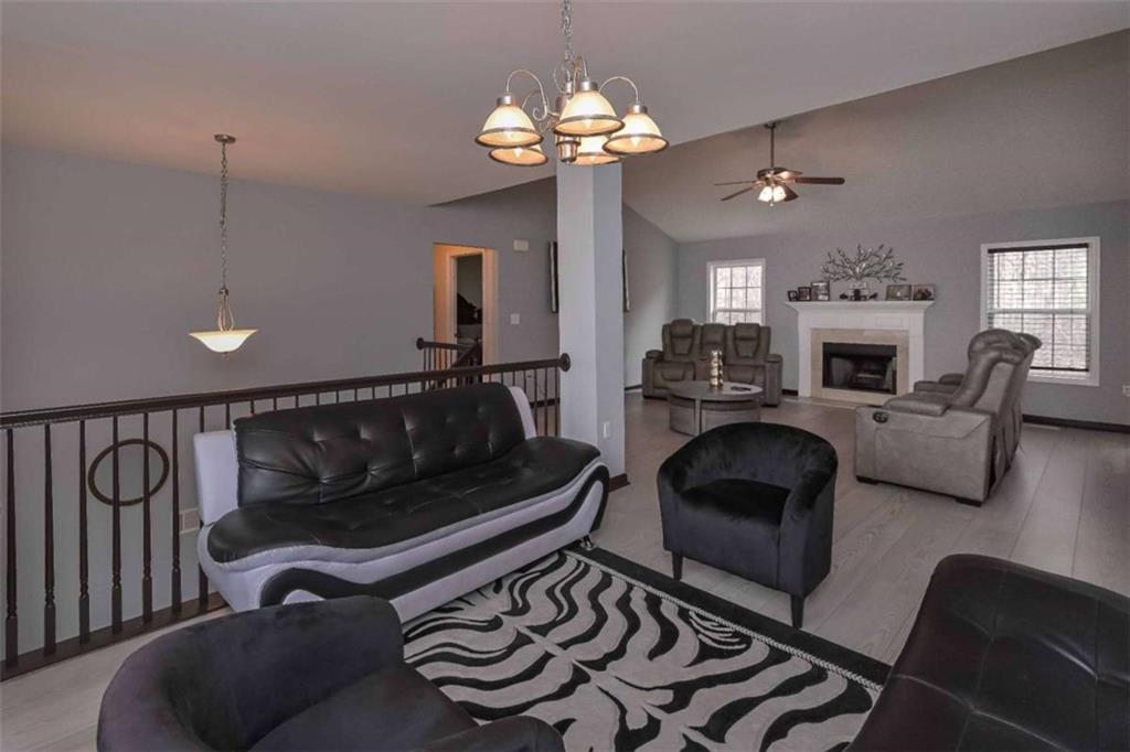 113 Millwheel Drive Villa Rica, GA 30180 - Photo 7 of 34 a living room with furniture a chandelier and a fireplace