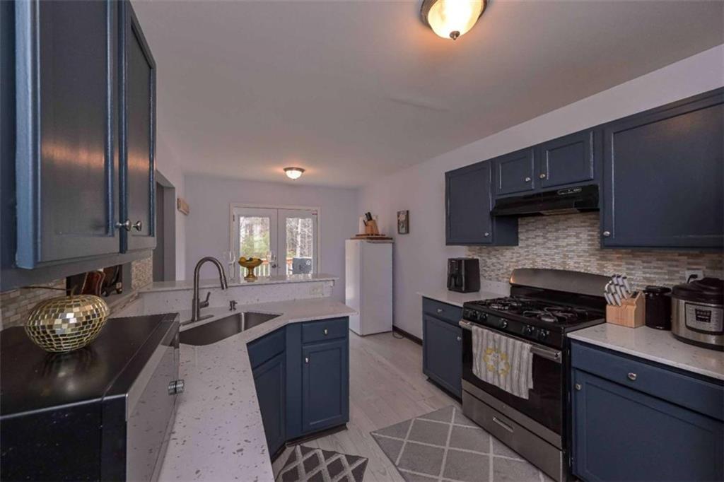 113 Millwheel Drive Villa Rica, GA 30180 - Photo 10 of 34 a kitchen with granite countertop a stove a sink and a refrigerator