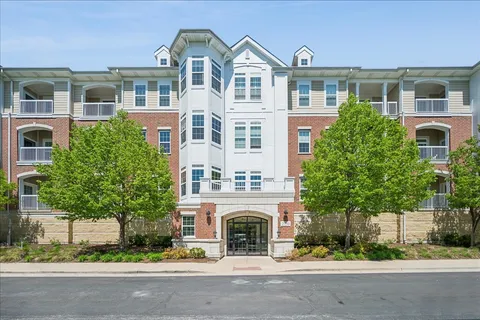 a front view of a building with a garden and plants