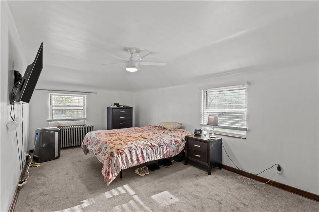 300 Highland Road Pittsburgh, PA 15235 - Photo 19 of 32 a bedroom with a bed next to a window and a flat screen tv