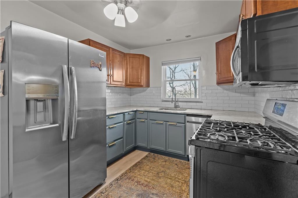 300 Highland Road Pittsburgh, PA 15235 - Photo 7 of 32 a kitchen with stainless steel appliances granite countertop a sink stove and refrigerator