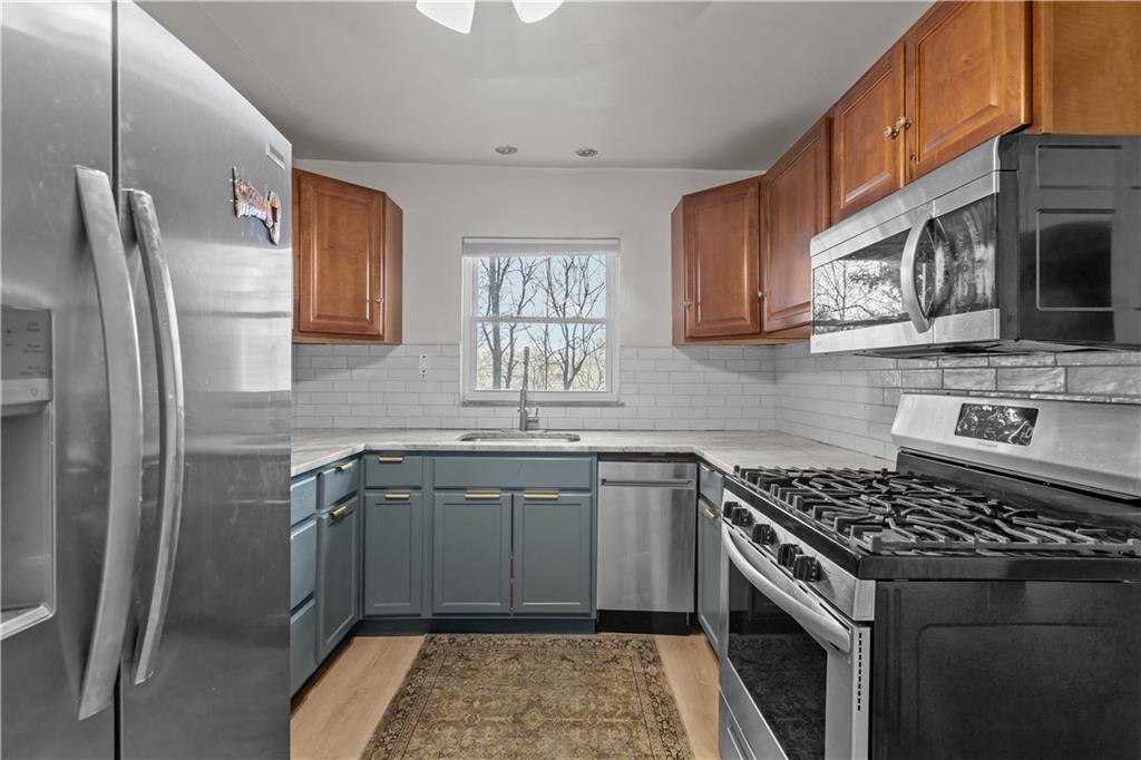 300 Highland Road Pittsburgh, PA 15235 - Photo 8 of 32 a kitchen with stainless steel appliances granite countertop a sink stove and refrigerator