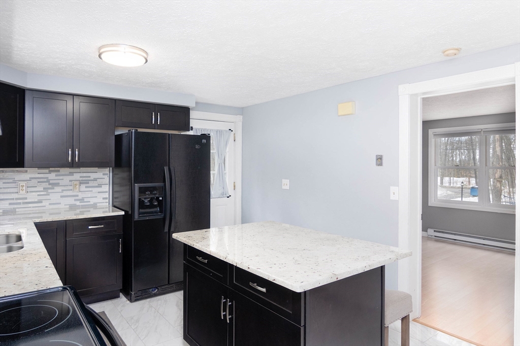336 Pommogussett Road Rutland, MA 01543 - Photo 8 of 31 a kitchen with a refrigerator and wooden cabinets
