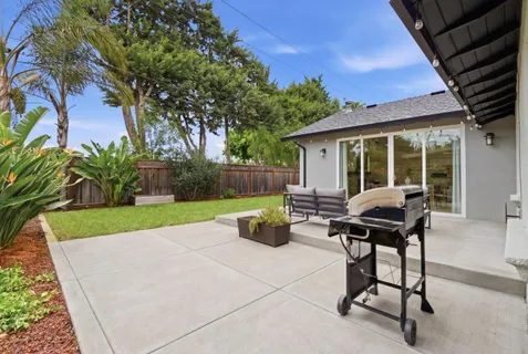 a view of a backyard with sitting area and garden