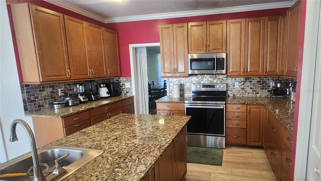 6839 Southwest 82 Terrace Gainesville, FL 32608 - Photo 9 of 28 a kitchen with a stove a sink and a microwave