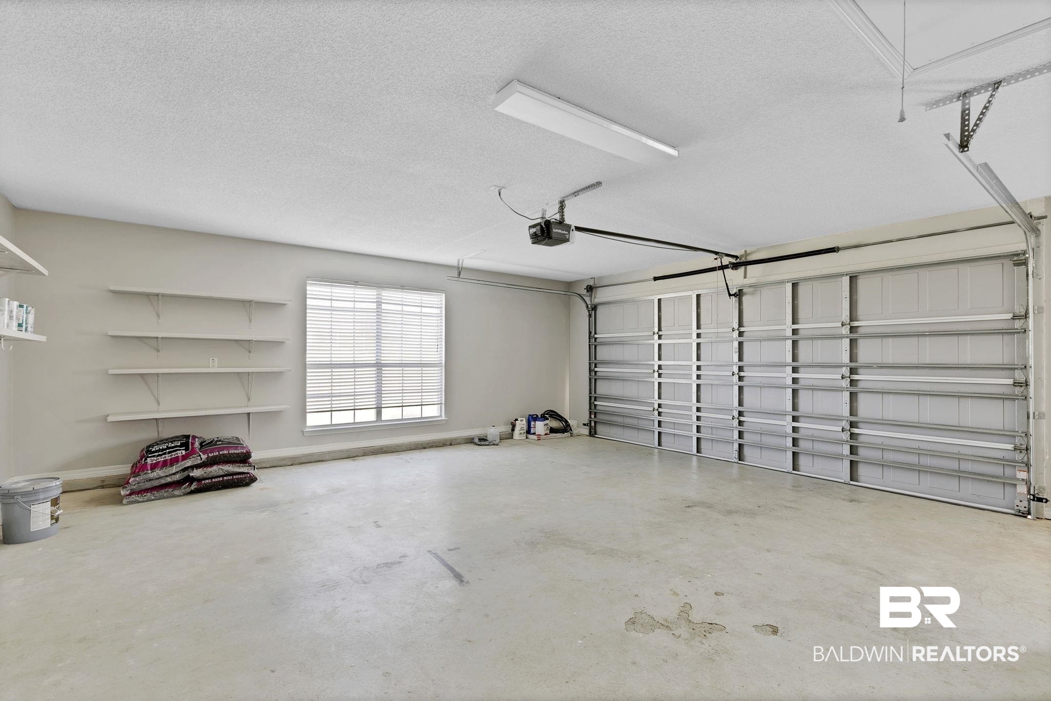 10238 Grove Drive Fairhope, AL 36532 - Photo 29 of 39 Garage with baseboards and a garage door opener