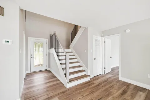 a view of empty room with wooden floor and fireplace