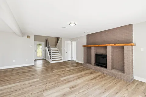 a view of a livingroom with wooden floor and stairs
