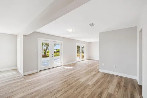 a view of empty room with wooden floor and fireplace