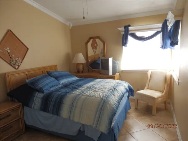 a bed sitting in a bedroom next to a lamp