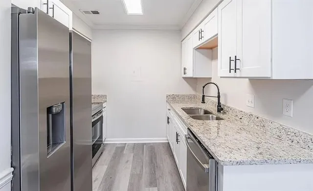 a kitchen with stainless steel appliances granite countertop a sink stove and refrigerator