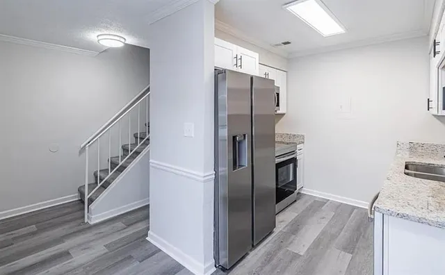 a kitchen with granite countertop a refrigerator and a sink