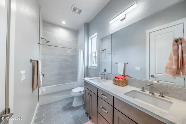 a bathroom with a double vanity sink mirror double shower and a toilet