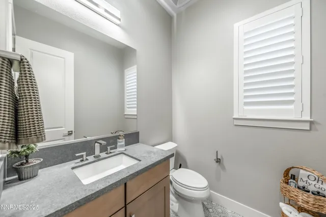 a bathroom with a granite countertop sink toilet and mirror