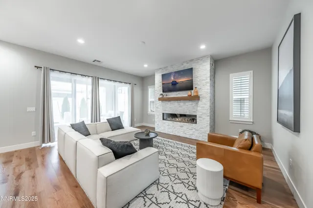 a living room with furniture a flat screen tv and a large window