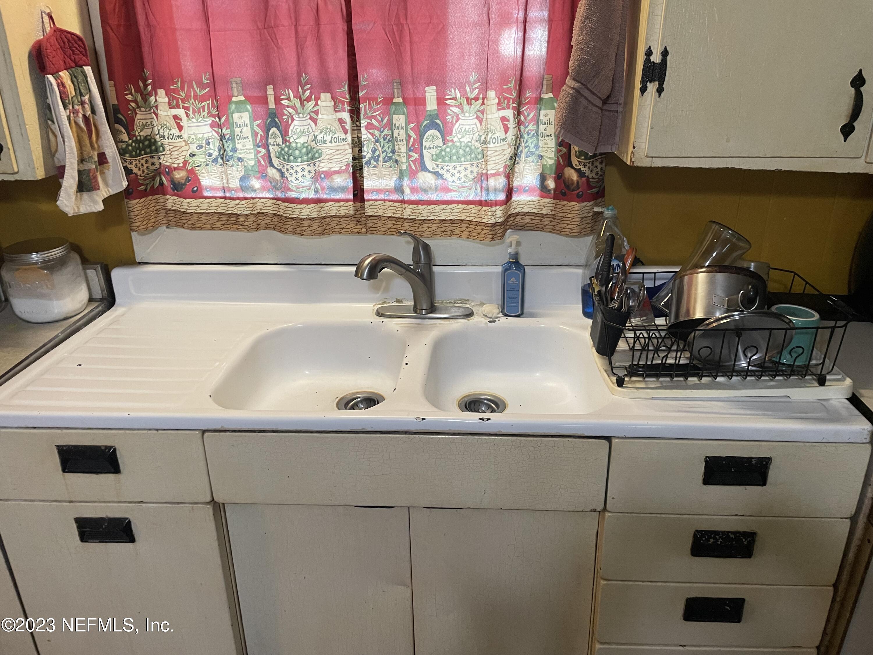 51 East 17th Street Jacksonville, FL 32206 - Photo 11 of 14 a kitchen with a sink a window and cabinets