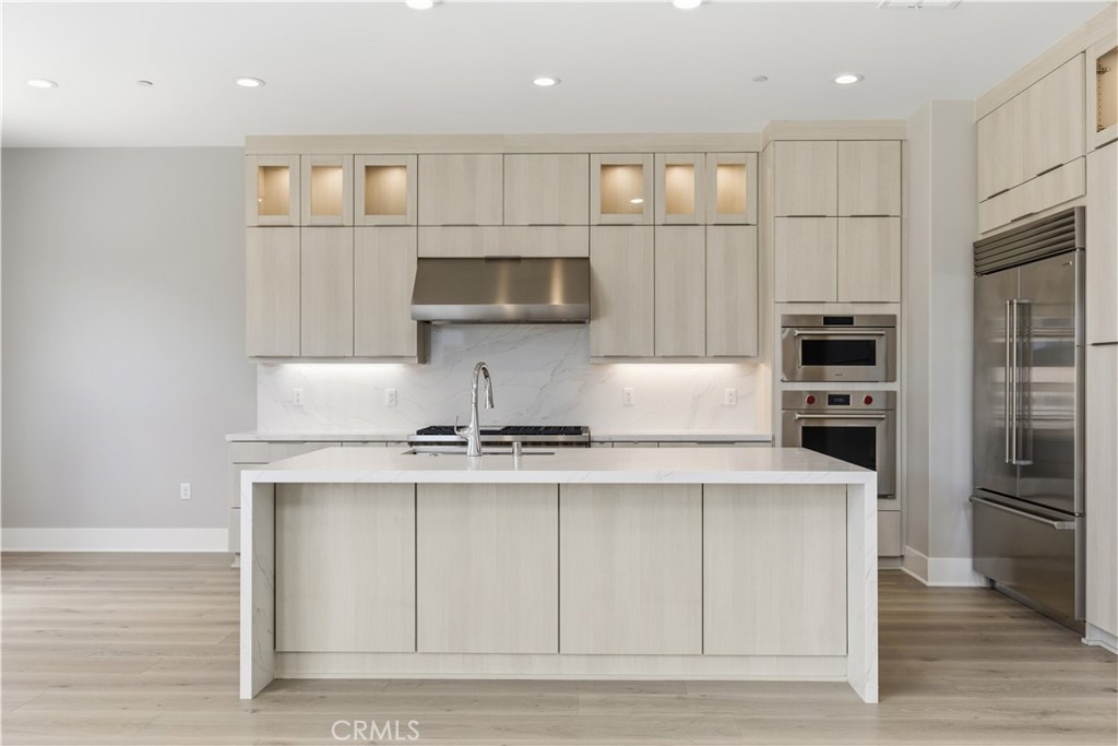 156 Apron Irvine, CA 92618 - Photo 6 of 40 a kitchen with kitchen island white cabinets and stainless steel appliances