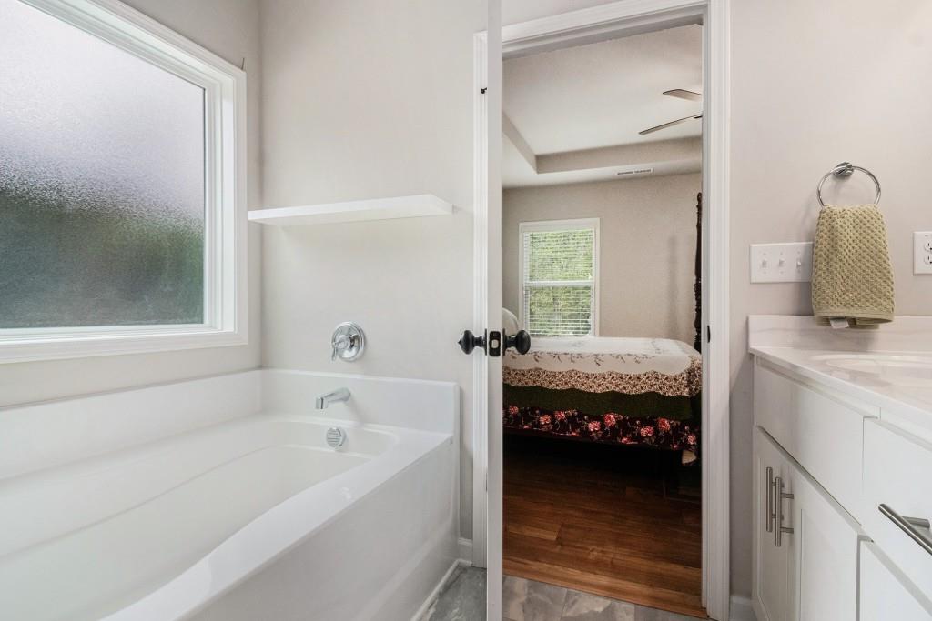 124 Willington Way Newnan, GA 30265 - Photo 18 of 41 a en suite bathroom with a tub sink and mirror