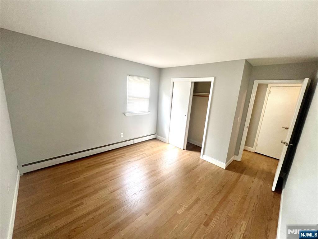 15-1 Spruce Street, Unit 151 Oakland, NJ 07436 - Photo 12 of 13 an empty room with wooden floor and mirror