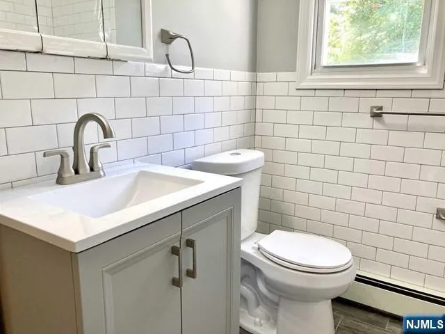 a bathroom with a sink a toilet and a mirror