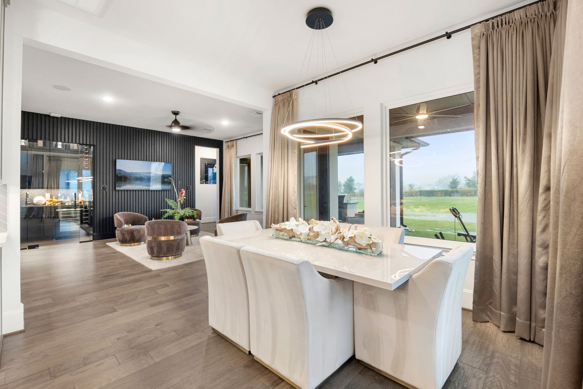 29419 Cir S Rnch Trail Fulshear, TX 77406 - Photo 15 of 45 The bright kitchen/dining combo area presents a sophisticated setting for formal meals, featuring a sleek modern chandelier and large windows looking out to the open backyard space.
