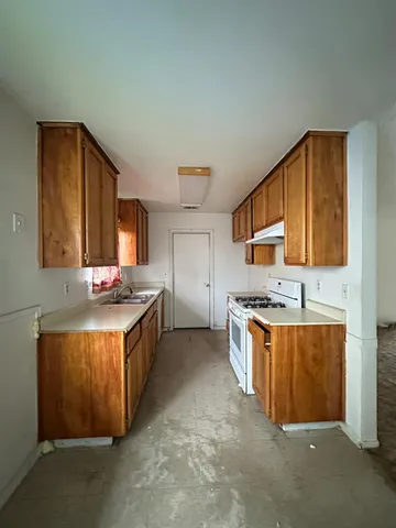 a large kitchen with stainless steel appliances granite countertop a stove and a sink
