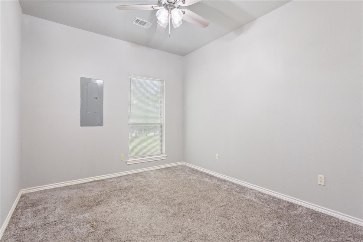 140 Oak Ridge Loop Whitney, TX 76692 - Photo 30 of 40 an empty room with a chandelier fan and windows