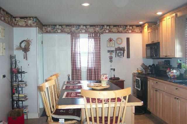 13900 West Howardsville Road Lena, IL 61048 - Photo 3 of 9 a kitchen with a table chairs stove and cabinets