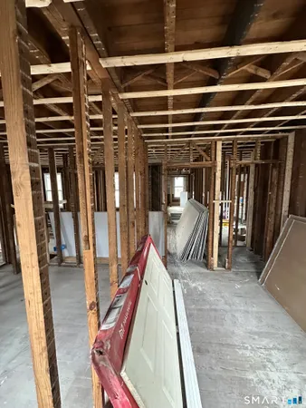 a view of an empty room with wooden floor and windows