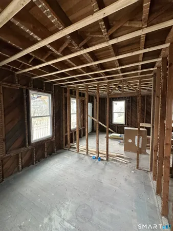 a view of a hall with wooden floor and furniture