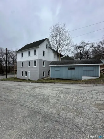 a view of a house with backyard and trees