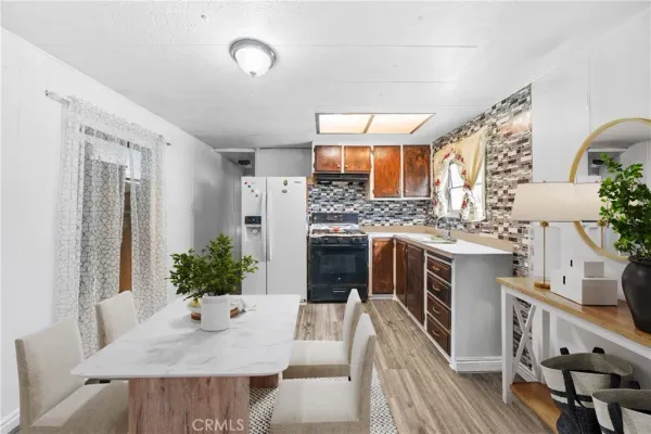 a living room with furniture a potted plant and a kitchen view