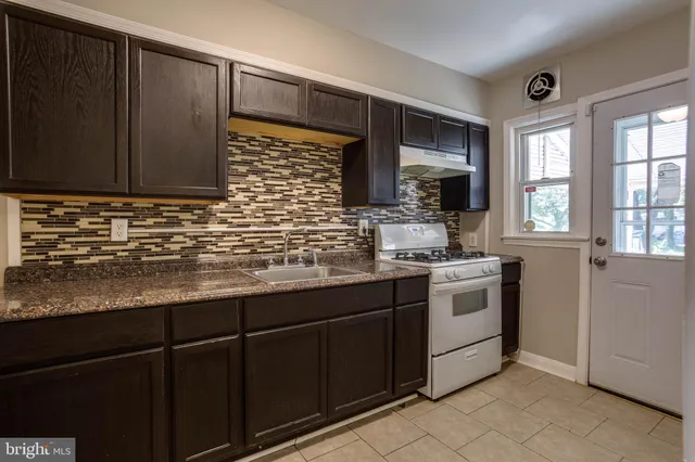 a kitchen with stainless steel appliances granite countertop a sink stove and microwave