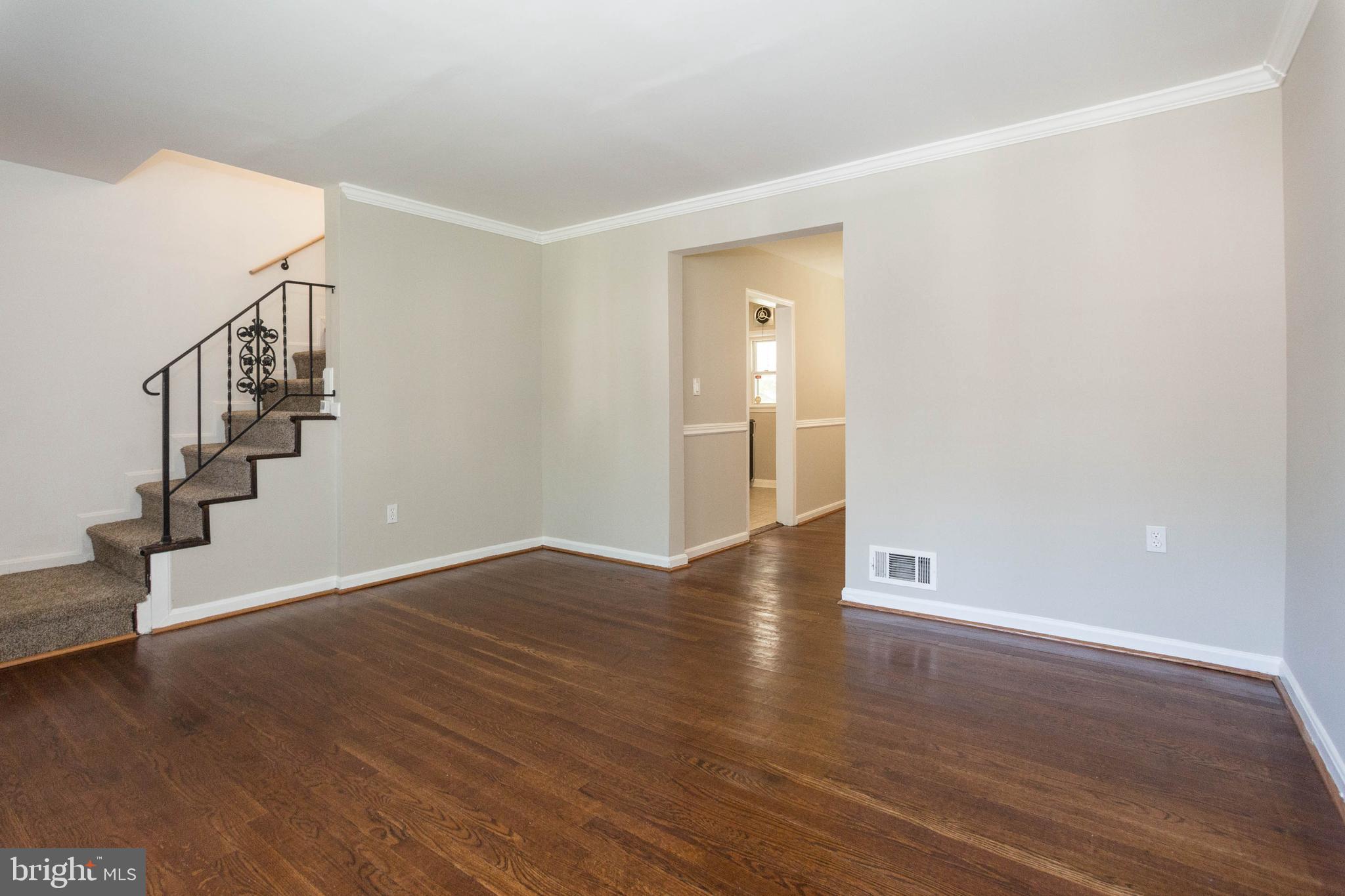1327 Limit Avenue Baltimore, MD 21239 - Photo 20 of 24 a view of an empty room with wooden floor and stairs