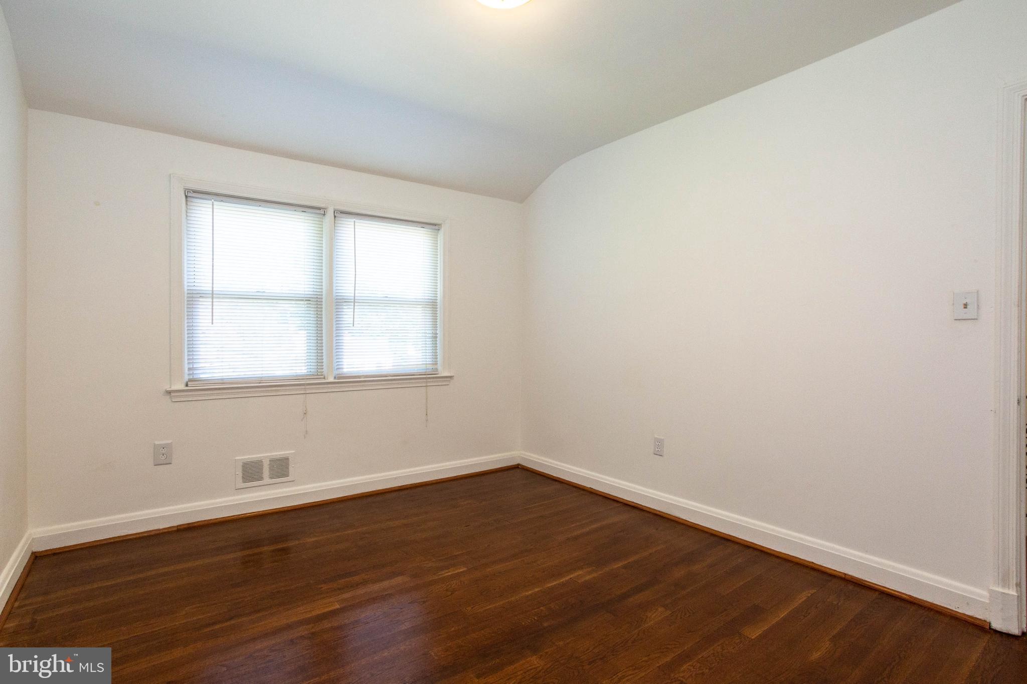 1327 Limit Avenue Baltimore, MD 21239 - Photo 22 of 24 wooden floor in an empty room with a window