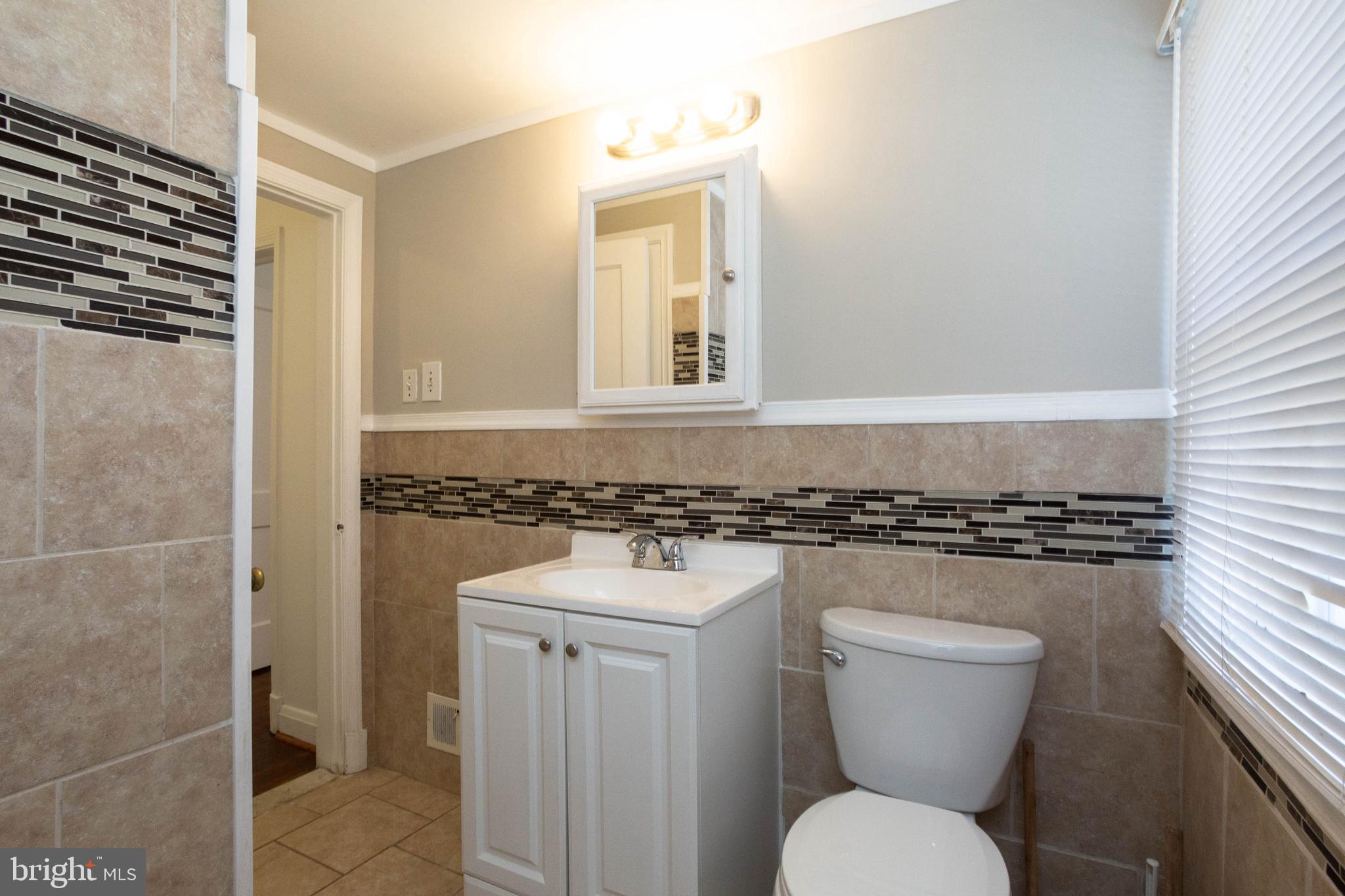 1327 Limit Avenue Baltimore, MD 21239 - Photo 9 of 24 a bathroom with a toilet a sink and a shower