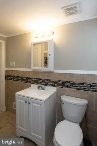 a bathroom with a granite countertop toilet sink and mirror