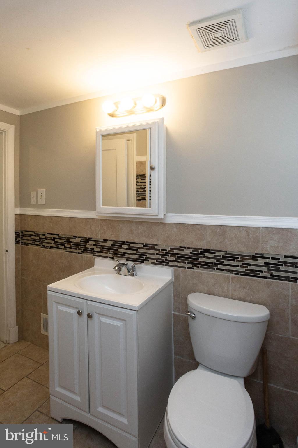 1327 Limit Avenue Baltimore, MD 21239 - Photo 10 of 24 a bathroom with a granite countertop toilet sink and mirror